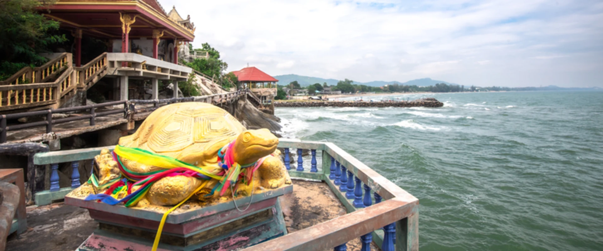 Golden turtle shrine beside a seaside temple hall at Wat Tham Khao Tao in Nong Kae, Hua Hin.