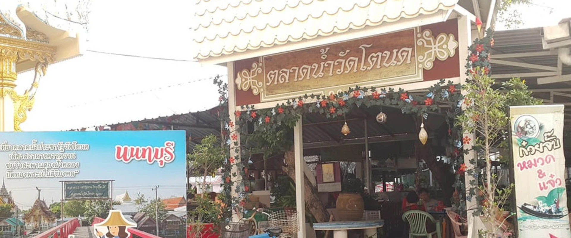 Wooden entrance pavilion with the Thai Wat Tanod Floating Market sign in Nonthaburi