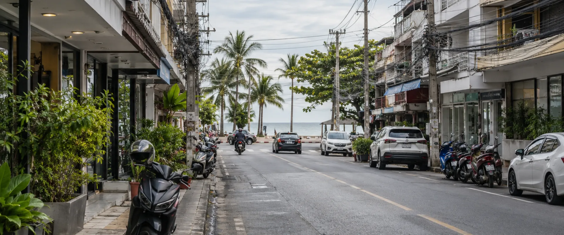AI-generated photographic-style context image of an ordinary Thai coastal street with overhead utility cables.
