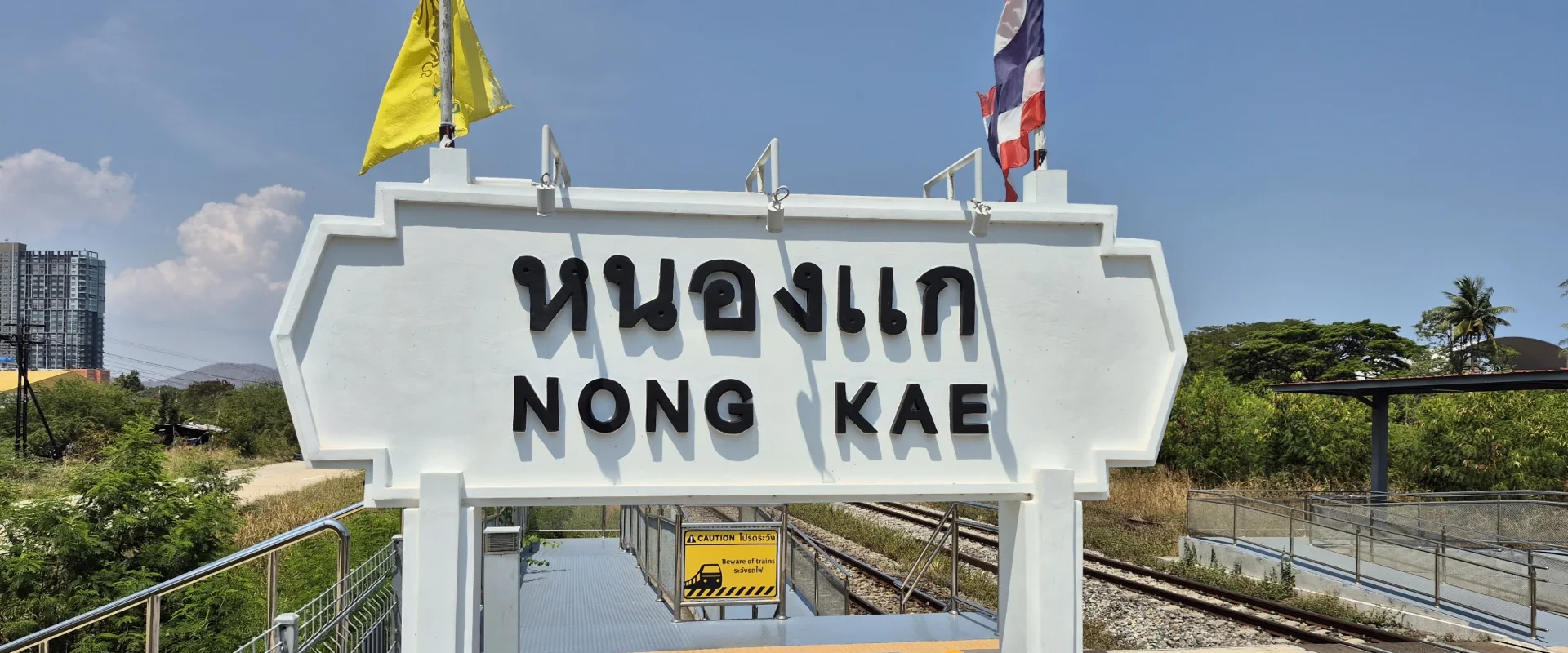 Thai and English NONG KAE railway-station sign beside the tracks and platforms in Nong Kae, Hua Hin.