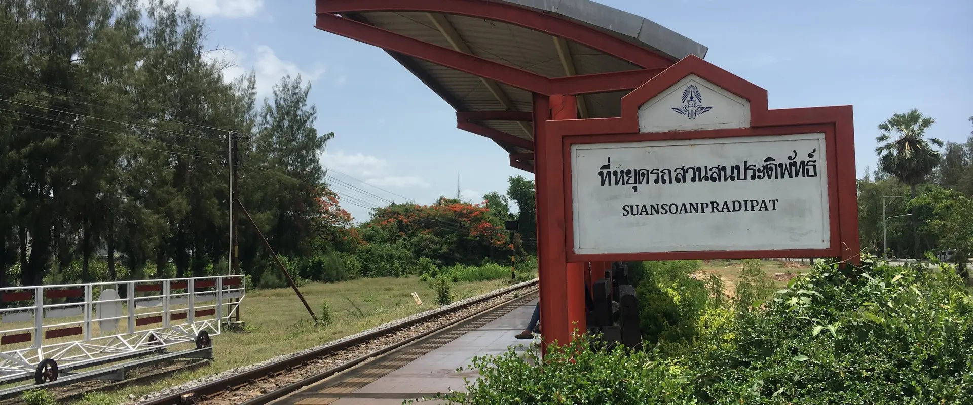 The bilingual Suan Son Pradiphat rail-stop sign beside the earlier halt platform and track.