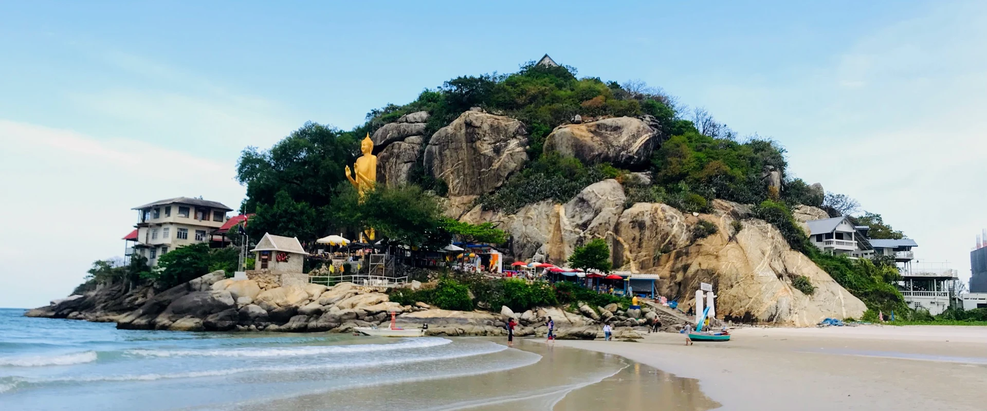 Takiab Beach north of Khao Takiab headland, with the standing Buddha and northern rock face visible above the sand.