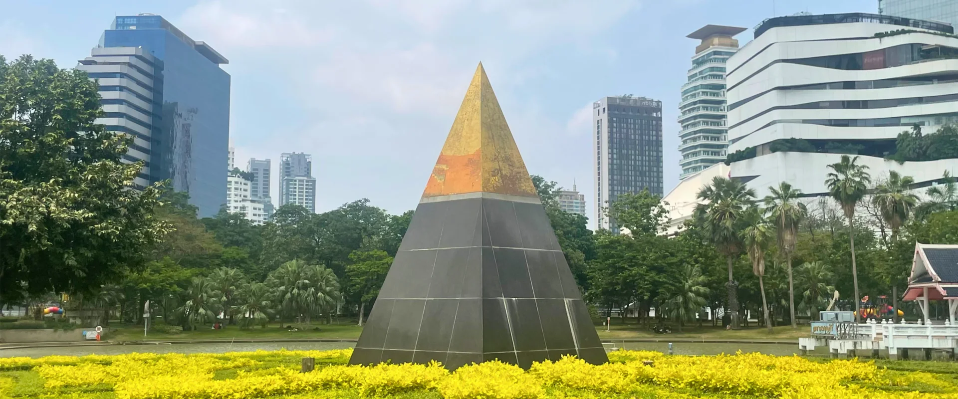 The gold-tipped Supreme Pinnacle, Firm Base pyramid sculpture beside the lake in Benchasiri Park, Bangkok.